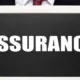 Homme en costume tenant une ardoise portant le mot « Assurance »