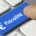 Touche de clavier bleue marquée « Fiscalité » avec le symbole euro, sous un doigt