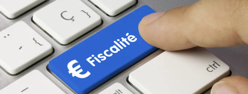 Touche de clavier bleue marquée « Fiscalité » avec le symbole euro, sous un doigt