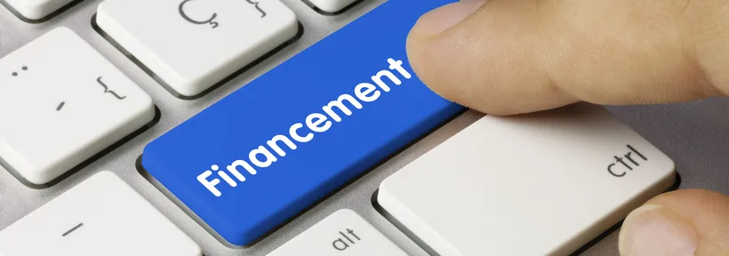 Touche de clavier bleue marquée « Financement » sous un doigt, pour l'assurance emprunteur