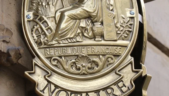 Enseigne dorée de notaire de la République française sur une façade en pierre