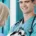 Vétérinaire souriant en tenue verte tenant un chiot dalmatien devant une collaboratrice