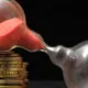 Sablier de sable rouge penché sur des piles de pièces, image du capital décès qui s'amenuise