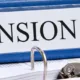 Classeur bleu étiqueté « Pension » posé à plat sur un bureau