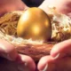 Œuf doré dans un nid de paille tenu entre deux mains, image de la réversion pour le conjoint