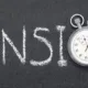 Chronomètre intégré au mot « Pension » écrit à la craie sur un tableau noir